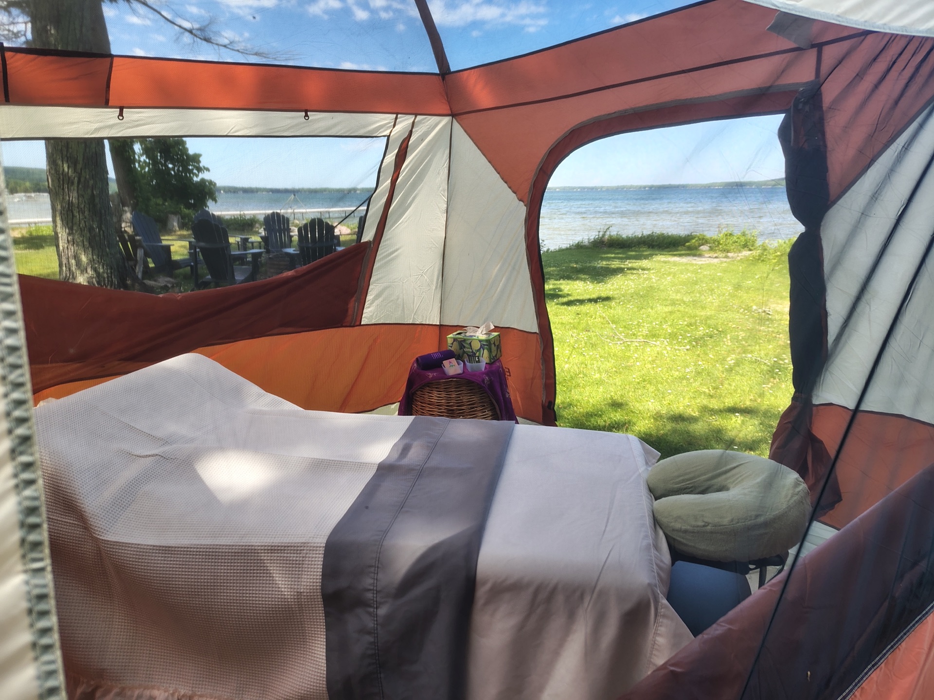 Inside a private massage tent with fresh linens and a lake view