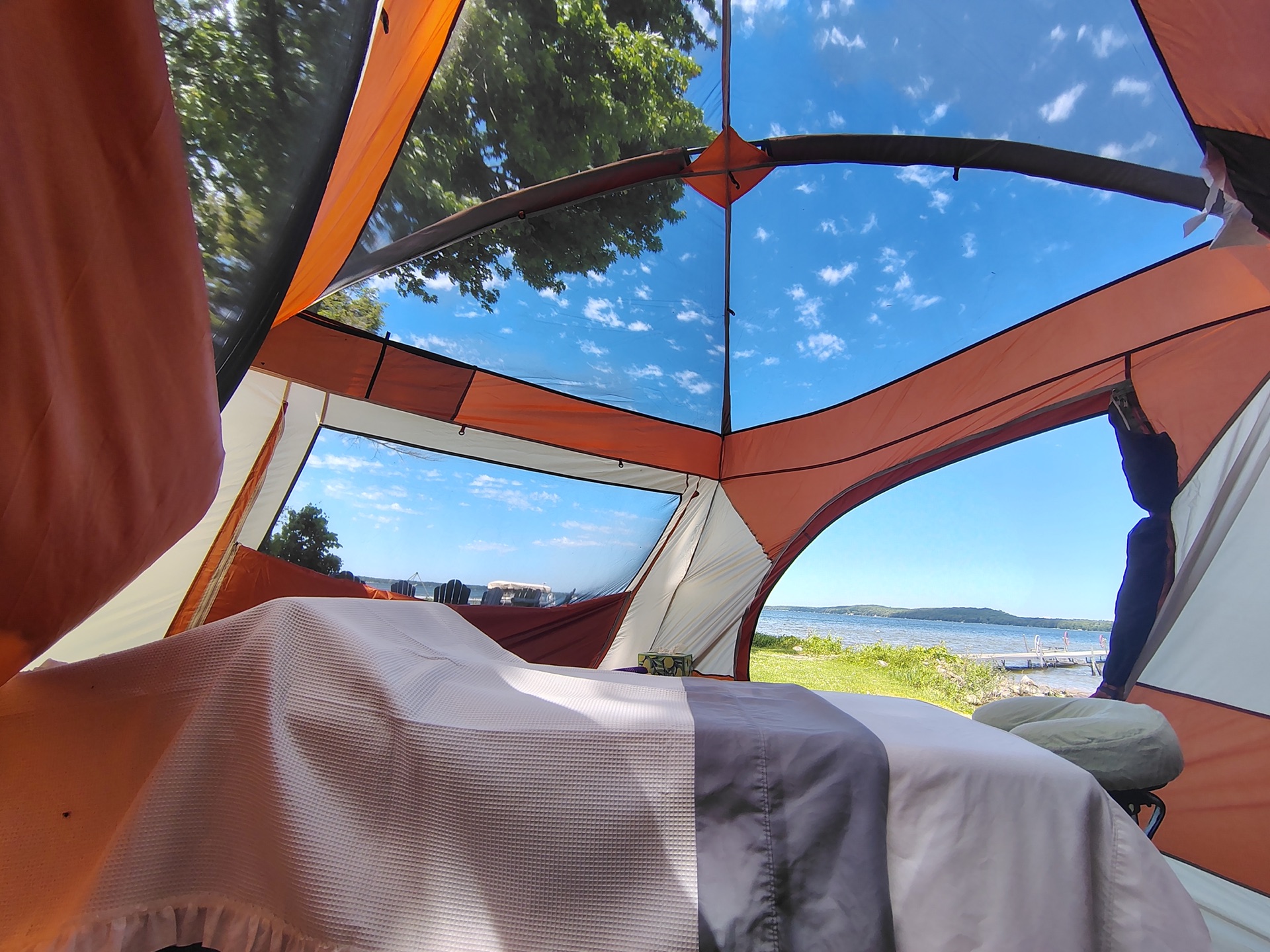 View from inside the massage tent looking up through the mesh roof to blue sky